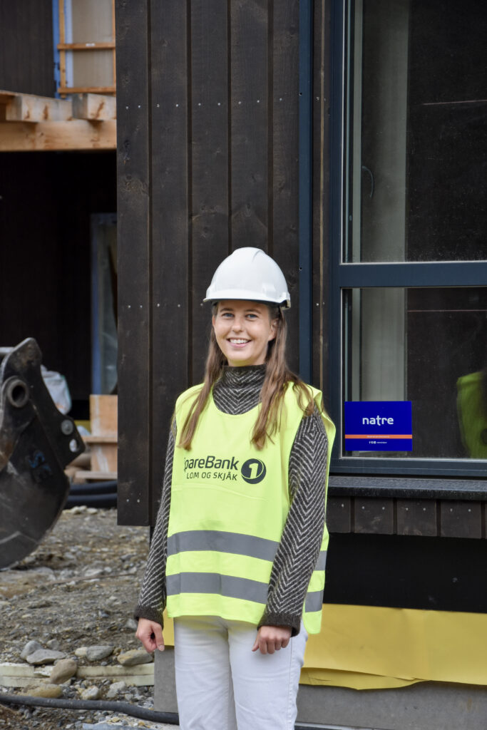 Dame utanfor den nye barnehagen i Skjåk som blir bygd
